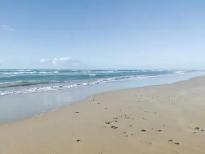 a beach with footprints in the sand and the ocean at 6 person holiday home in Brovst in Brovst