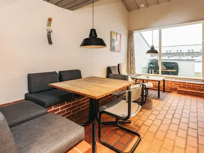 a dining room with a table and chairs and a window at 6 person holiday home in Brovst in Brovst