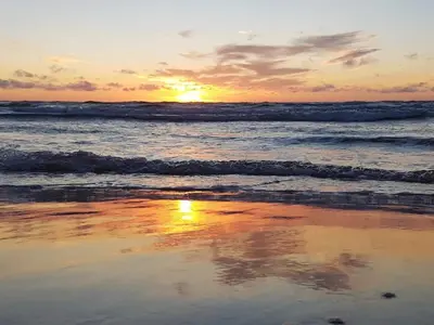 a sunset on the beach with the ocean at 6 person holiday home in Brovst in Brovst