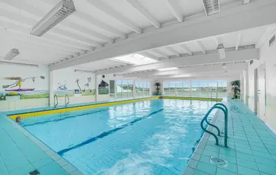 a large indoor swimming pool with blue water at Gorgeous Apartment In Vestervig in Vestervig