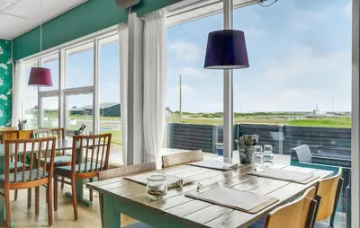 a dining room with a table and a large window at Gorgeous Home In Vestervig With Sauna in Vestervig
