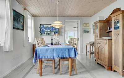 a dining room with a blue table and chairs at Two-Bedroom Holiday Home Thyholm With Sea View 04 in Thyholm