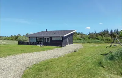 a small black house on a gravel road at Three-Bedroom Holiday Home Hurup Thy With A Fireplace 06 in Sindrup
