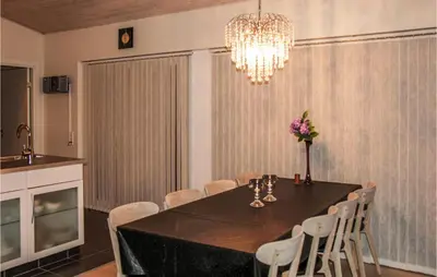 a dining room with a table and chairs and a chandelier at Three-Bedroom Holiday Home Hurup Thy With A Fireplace 06 in Sindrup