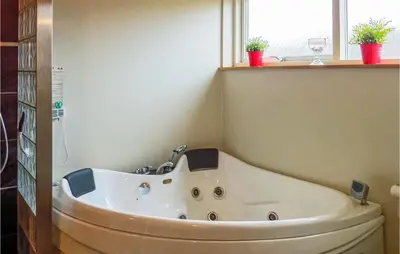 a bath tub in a bathroom with a window at Three-Bedroom Holiday Home Hurup Thy With A Fireplace 06 in Sindrup