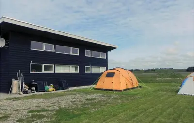 an orange tent in the grass next to a building at Three-Bedroom Holiday Home Hurup Thy With A Fireplace 06 in Sindrup