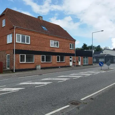 a brick building on the side of a street at Hyggelig lejlighed i stille by in Vemb