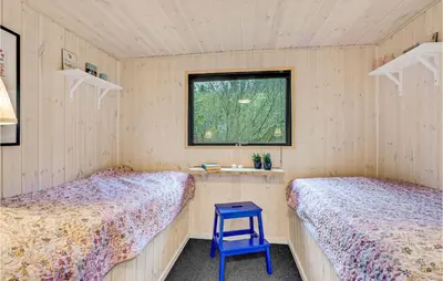 a room with two beds and a blue stool at Two-Bedroom Holiday Home Nibe With A Fireplace 06 in Nibe