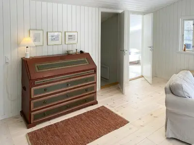 a living room with a dresser and a couch at Relaxed Summer House By The North Sea in Blokhus