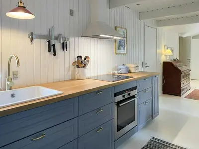 a kitchen with blue cabinets and a sink at Relaxed Summer House By The North Sea in Blokhus