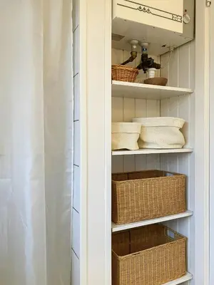 a kitchen pantry with baskets and wicker baskets at Relaxed Summer House By The North Sea in Blokhus