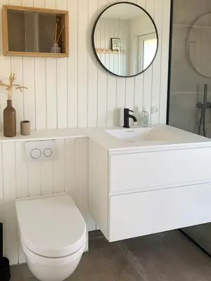 a white bathroom with a toilet and a mirror at Nordic 70S Gem Amidst The Dunes in Blokhus