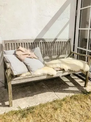 a wooden bench sitting on the side of a building at In Cold Hawaii With Beach In Backyard in Torsted