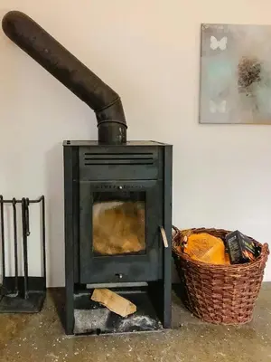 a stove with a pipe next to a basket at In Cold Hawaii With Beach In Backyard in Torsted
