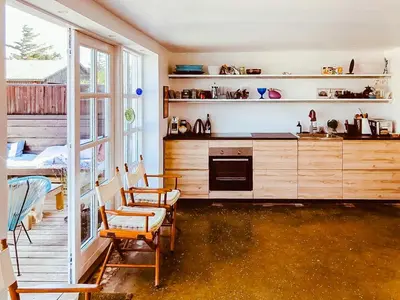 a kitchen with a counter and chairs in a room at In Cold Hawaii With Beach In Backyard in Torsted