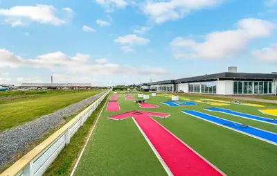 a row of colorful mats on a field in front of a building at Cozy Home In Vestervig With Sauna in Vestervig