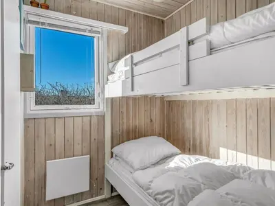 a bedroom with a bunk bed and a window at Holiday Home Alrike - 200m from the sea by Interhome in Brovst