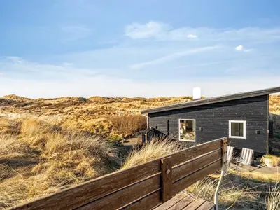 a house in the dunes with a wooden fence at Holiday Home Alrike - 200m from the sea by Interhome in Brovst