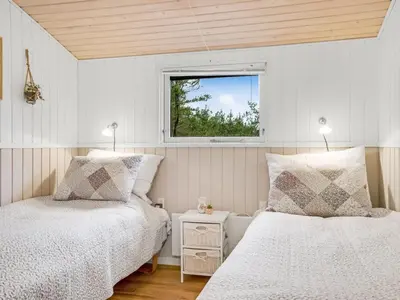 a bedroom with two beds and a window at Holiday Home Hansa - 3km from the sea by Interhome in Blokhus