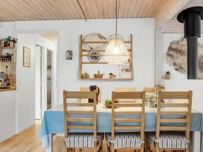 a dining room with a blue table and chairs at Holiday Home Hansa - 3km from the sea by Interhome in Blokhus