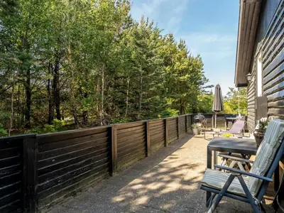 a patio with a fence and two chairs on it at Holiday Home Hansa - 3km from the sea by Interhome in Blokhus