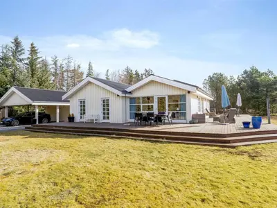 a house with a deck and a patio at Holiday Home Toska - 3km from the sea by Interhome in Blokhus