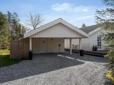 a large white garage with a fence at Holiday Home Toska - 3km from the sea by Interhome in Blokhus