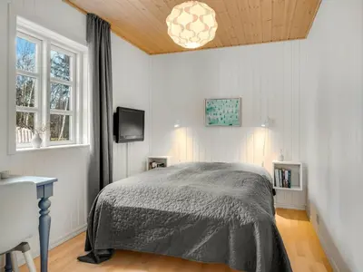 a bedroom with a bed and a television in it at Holiday Home Toska - 3km from the sea by Interhome in Blokhus