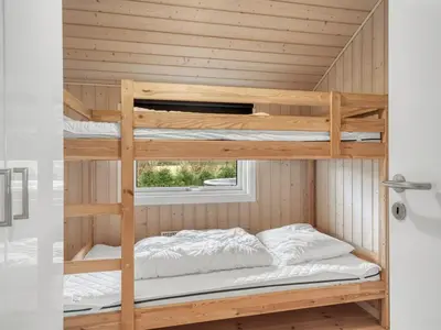 a bunk bed room with two bunk beds at Holiday Home Antero - 500m to the fjord by Interhome in Spottrup