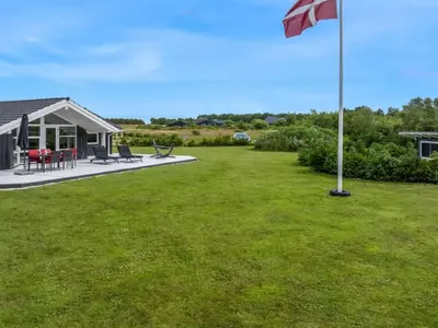 a flag pole in the yard of a house at Holiday Home Antero - 500m to the fjord by Interhome in Spottrup