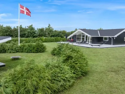 a house with a canadian flag in the yard at Holiday Home Antero - 500m to the fjord by Interhome in Spottrup