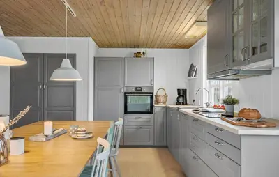 a kitchen with gray cabinets and a wooden table at Nice Home In Vinderup With Wifi in Vinderup