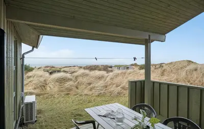 a table on a porch with a view of the beach at Cozy Home In Saltum With House Sea View in Saltum