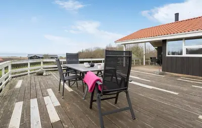 a table and chairs on the deck of a house at 3 Bedroom Amazing Home In Spøttrup in Spottrup