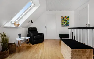 a living room with a black chair and a window at 3 Bedroom Cozy Home In Farsø in Farsø