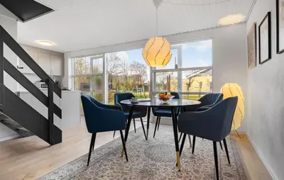 a dining room with a table and blue chairs at 3 Bedroom Cozy Home In Farsø in Farsø