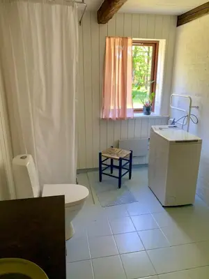 a bathroom with a toilet and a sink and a window at Unique location in Thy in Thisted