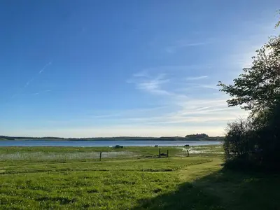 a field of grass with a body of water at Unique location in Thy in Thisted