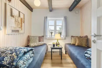 a living room with two blue couches and a window at Natural Gem Between Heath And Dunes in Thisted