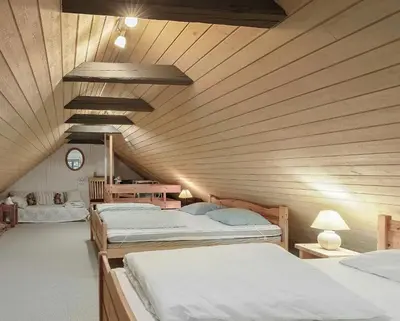 two beds in a room with a wooden ceiling at Natural Gem Between Heath And Dunes in Thisted