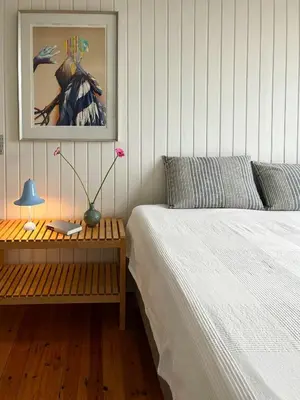 a bedroom with two beds and a table with a lamp at Wooden House In The Dunes Close To The Sea in Pandrup