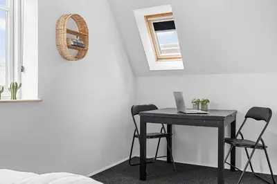 a table with two chairs and a laptop on it at Newly renovated house in the center in Thyborøn
