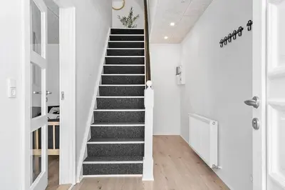 a staircase in a home with black and white stairs at Newly renovated house in the center in Thyborøn