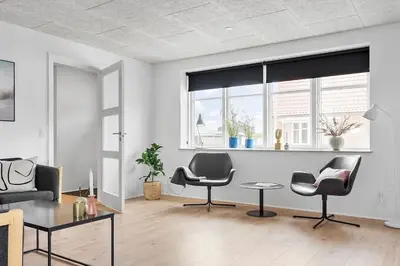 a living room with two chairs and a table at Newly renovated house in the center in Thyborøn
