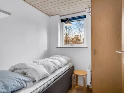a bed in a room with a window at Holiday Home Marika - 400m to the fjord by Interhome in Spottrup