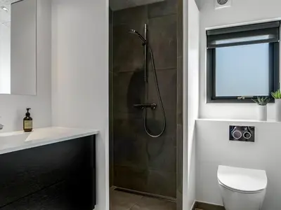 a bathroom with a shower with a glass door at Holiday Home Eriksine - 750m from the sea by Interhome in Løkken