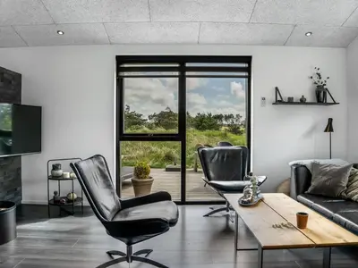 a living room with two chairs and a table at Holiday Home Eriksine - 750m from the sea by Interhome in Løkken