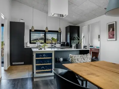 a kitchen with a wooden table and a dining room at Holiday Home Eriksine - 750m from the sea by Interhome in Løkken