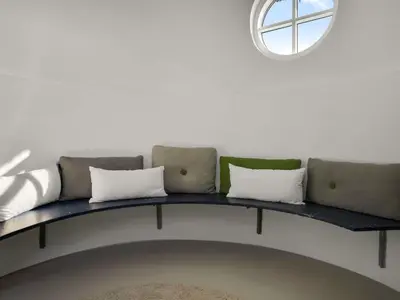 a couch in a room with a circular window at Holiday Home Amina - 200m from the sea by Interhome in Blokhus