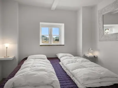 a white room with three beds in front of a window at Holiday Home Amina - 200m from the sea by Interhome in Blokhus